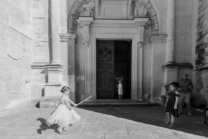 Enfants jouant devant une église lors d'un mariage à Grignan